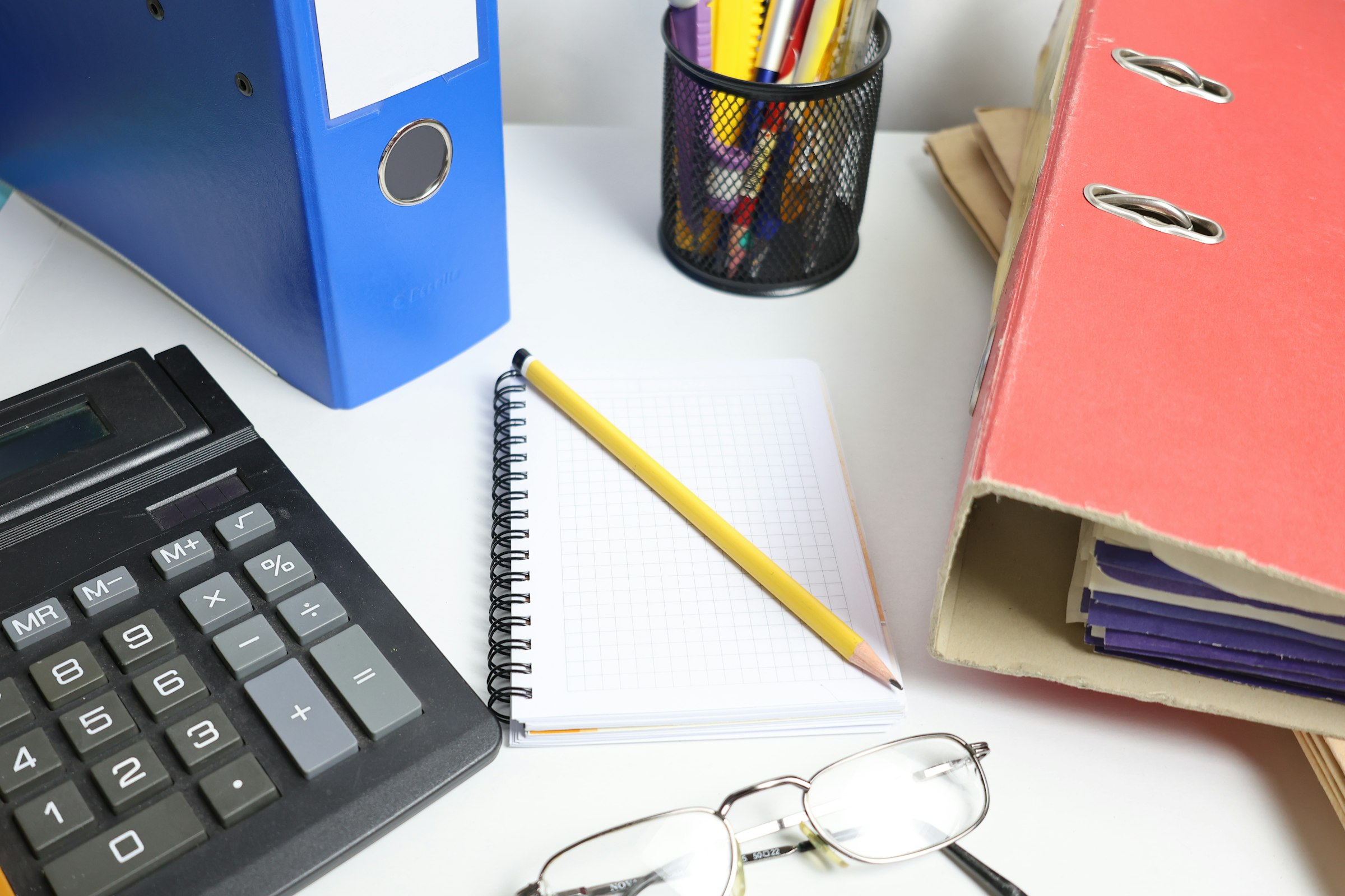 Orçamento de IA na agência de marketing: mesa com calculadora, pastas e planilhas de orçamento