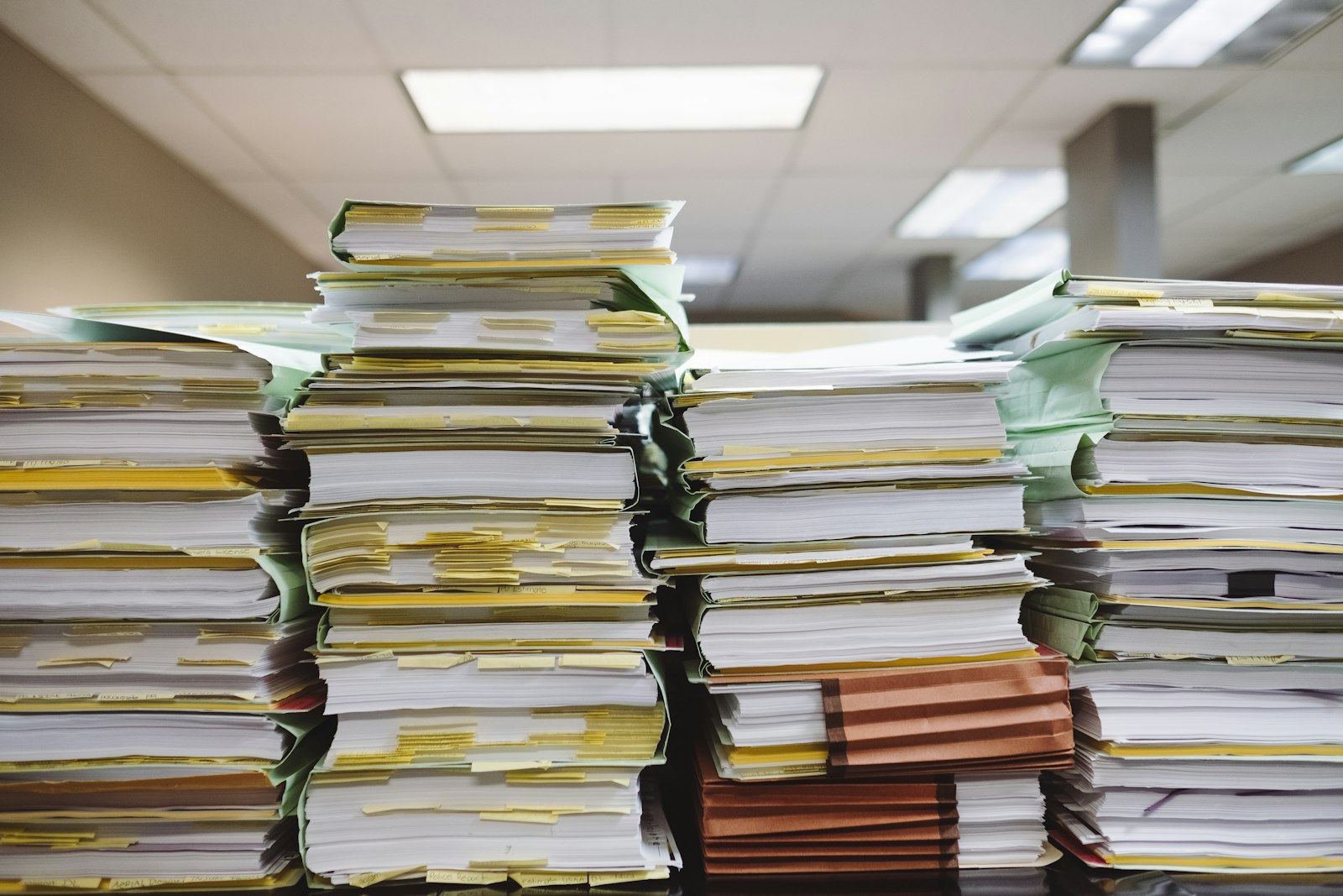 Pilhas de documentos e pastas de arquivo em escritório, imagem sobre o registro que LGPD e IA no marketing exigem da operação