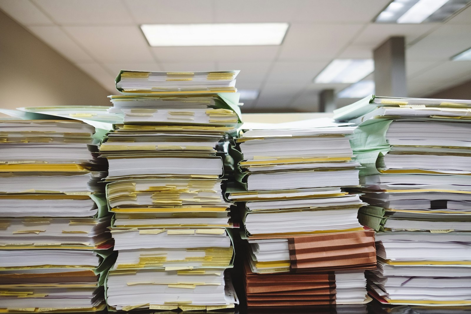 Pilhas de documentos empilhados num escritório, ilustrando o volume de dados para IA no marketing acumulado sem organização