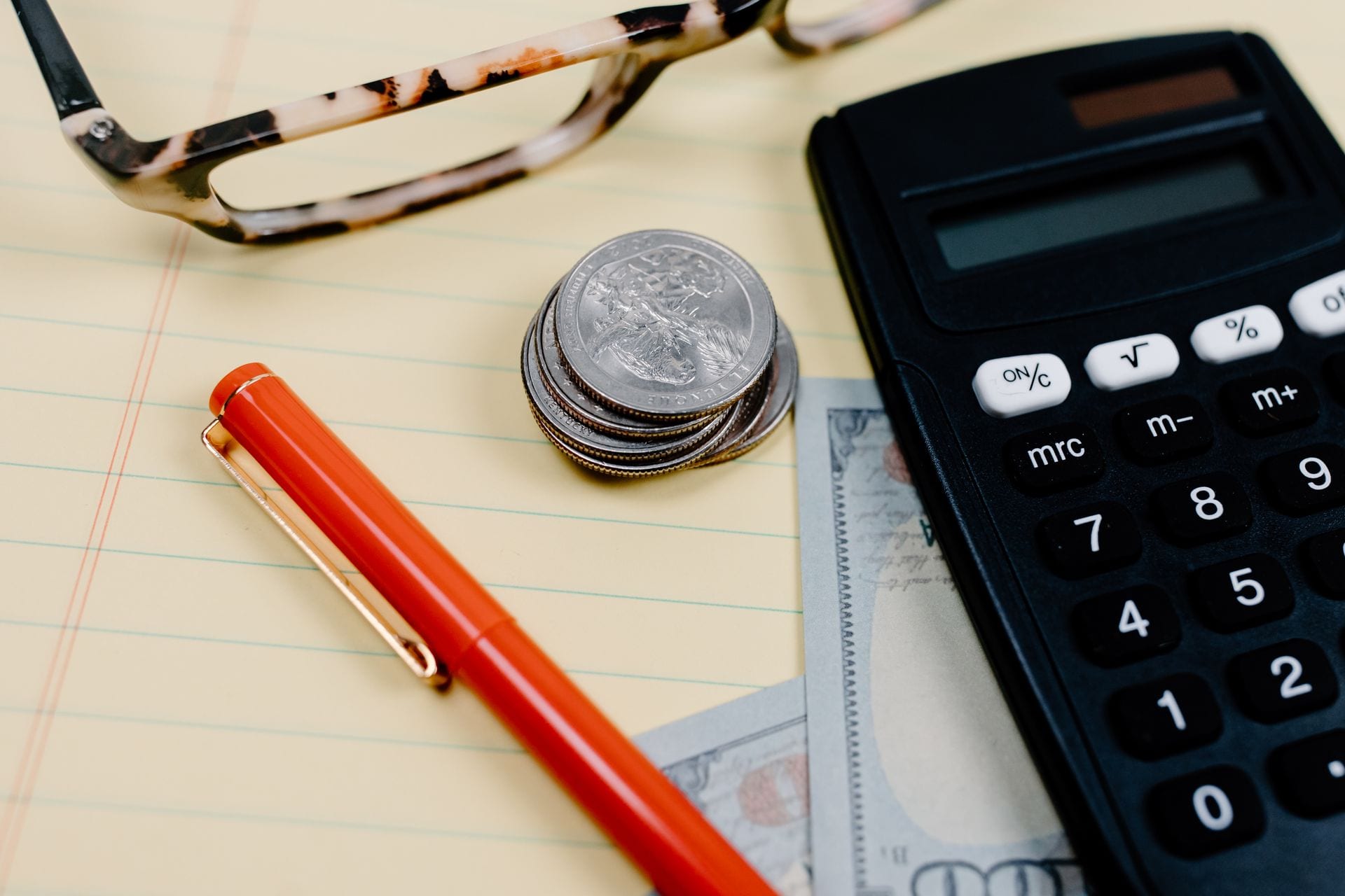 Moedas empilhadas ao lado de uma calculadora, quanto custa anunciar no ChatGPT Ads por enquanto