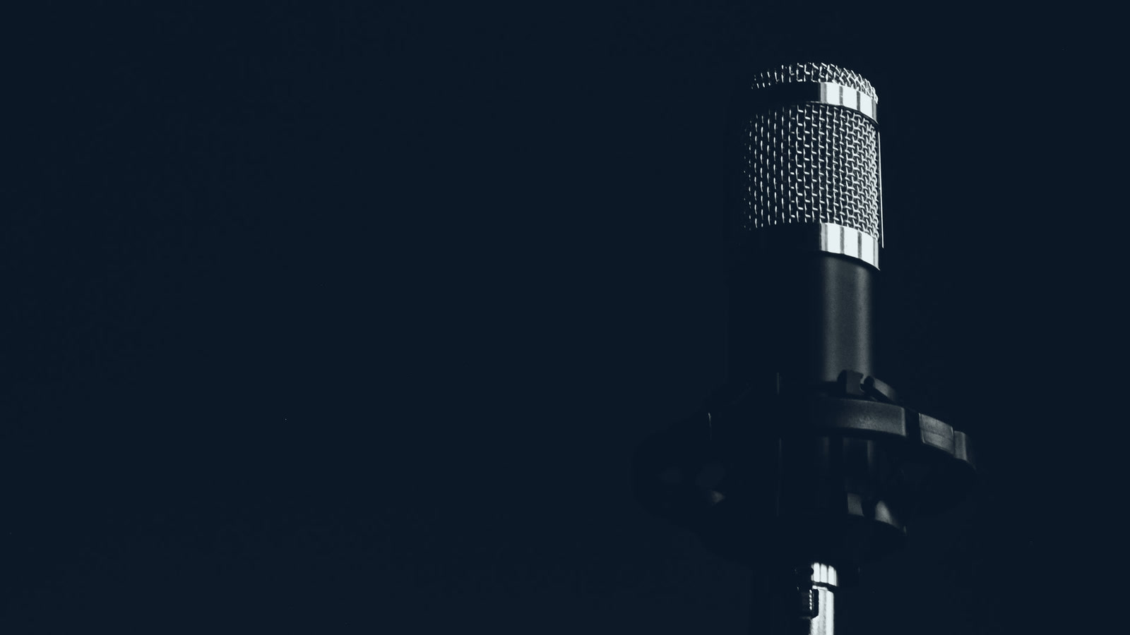 Microfone de estúdio no escuro, símbolo da voz da marca que precisa soar igual em todo canal