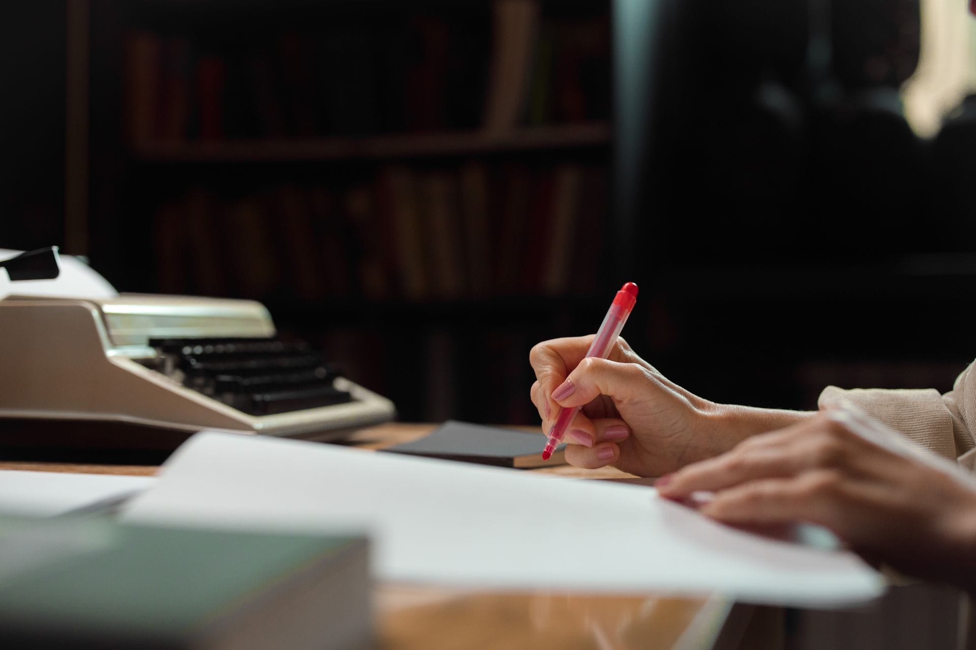 Editor revisando texto impresso com caneta, o sinal de qualidade no marketing de conteúdo com IA