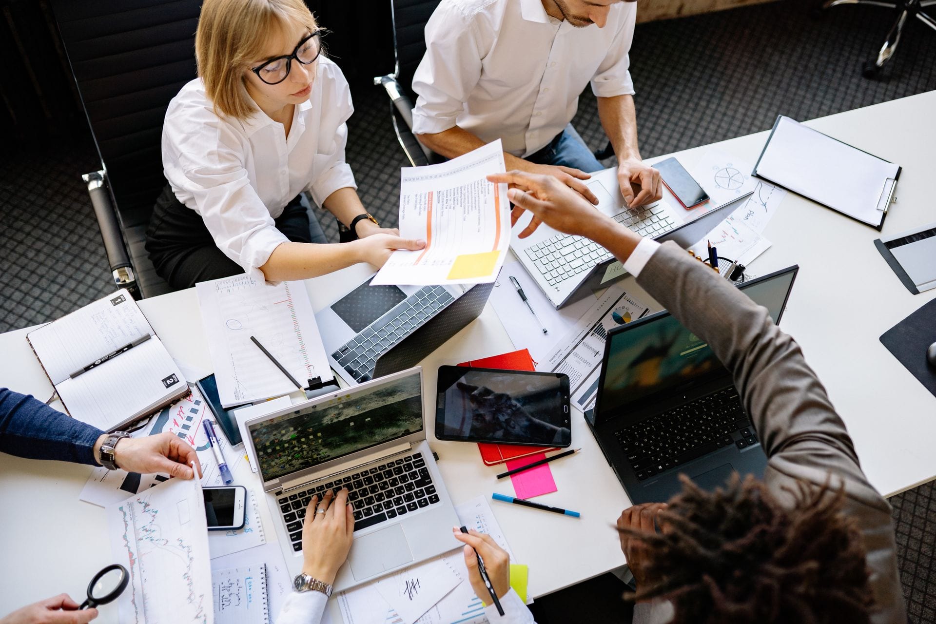 Equipe trabalhando lado a lado com notebooks, o que a gente vê numa operação de marketing com IA madura