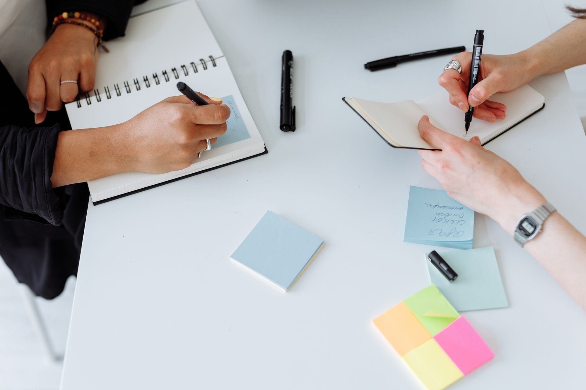 Duas pessoas comparando anotações numa mesa, automatizar e complementar num time de marketing com IA