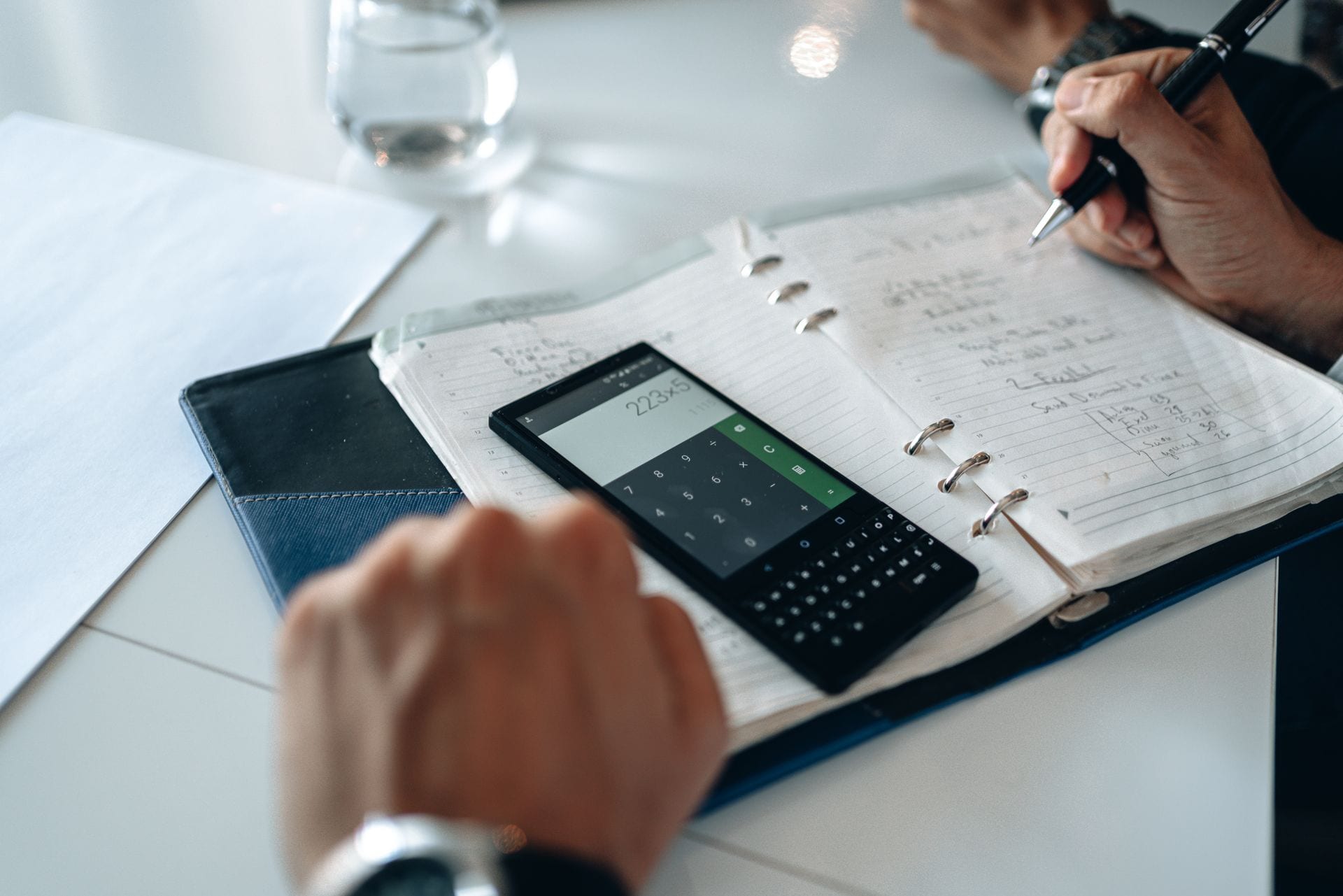 Calculadora e caderno de contas sobre a mesa, a conta que fecha quando você passa a operar com IA