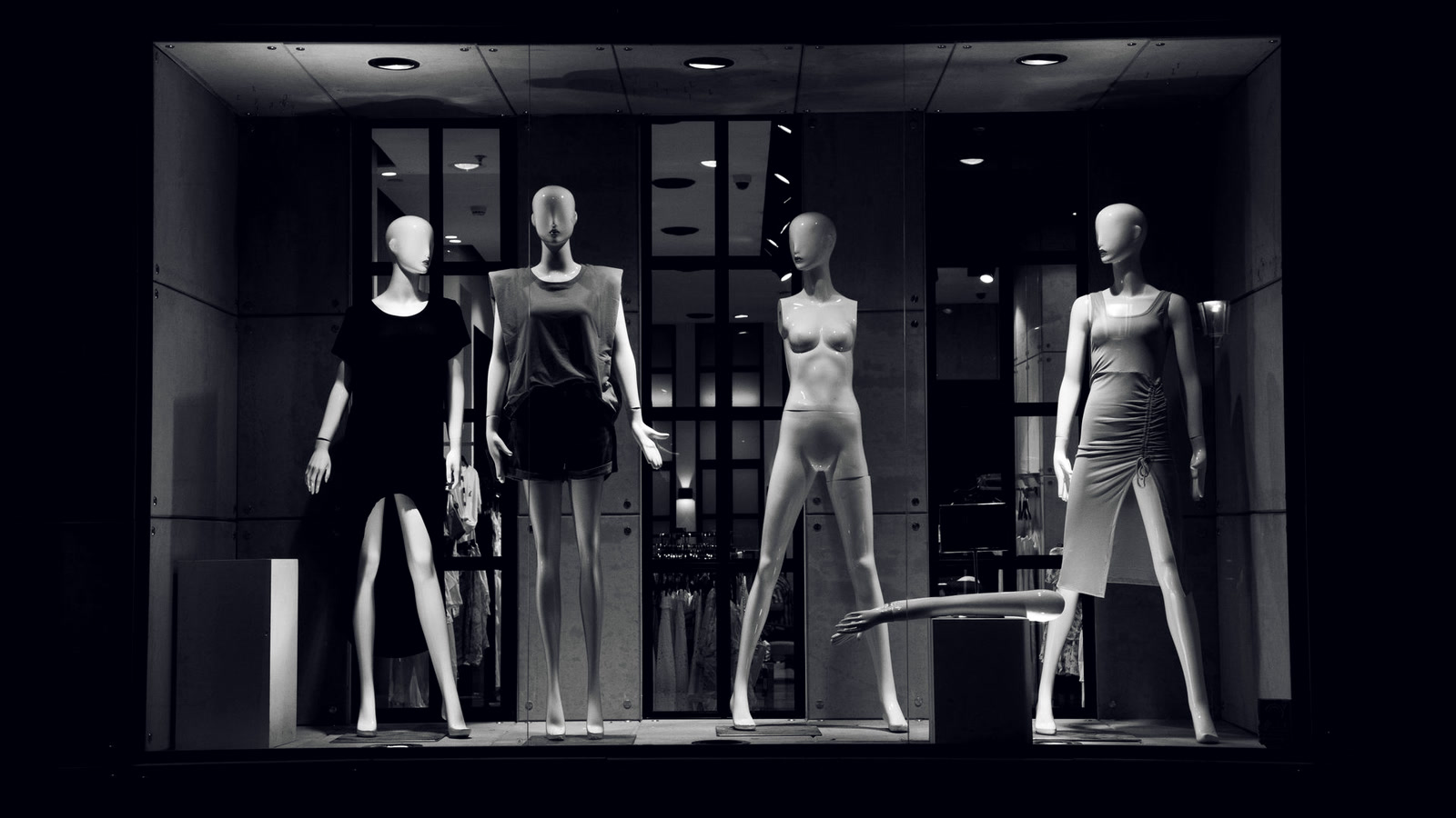 Manequins sem rosto numa vitrine iluminada, metáfora do consumidor sintético na pesquisa de mercado com IA