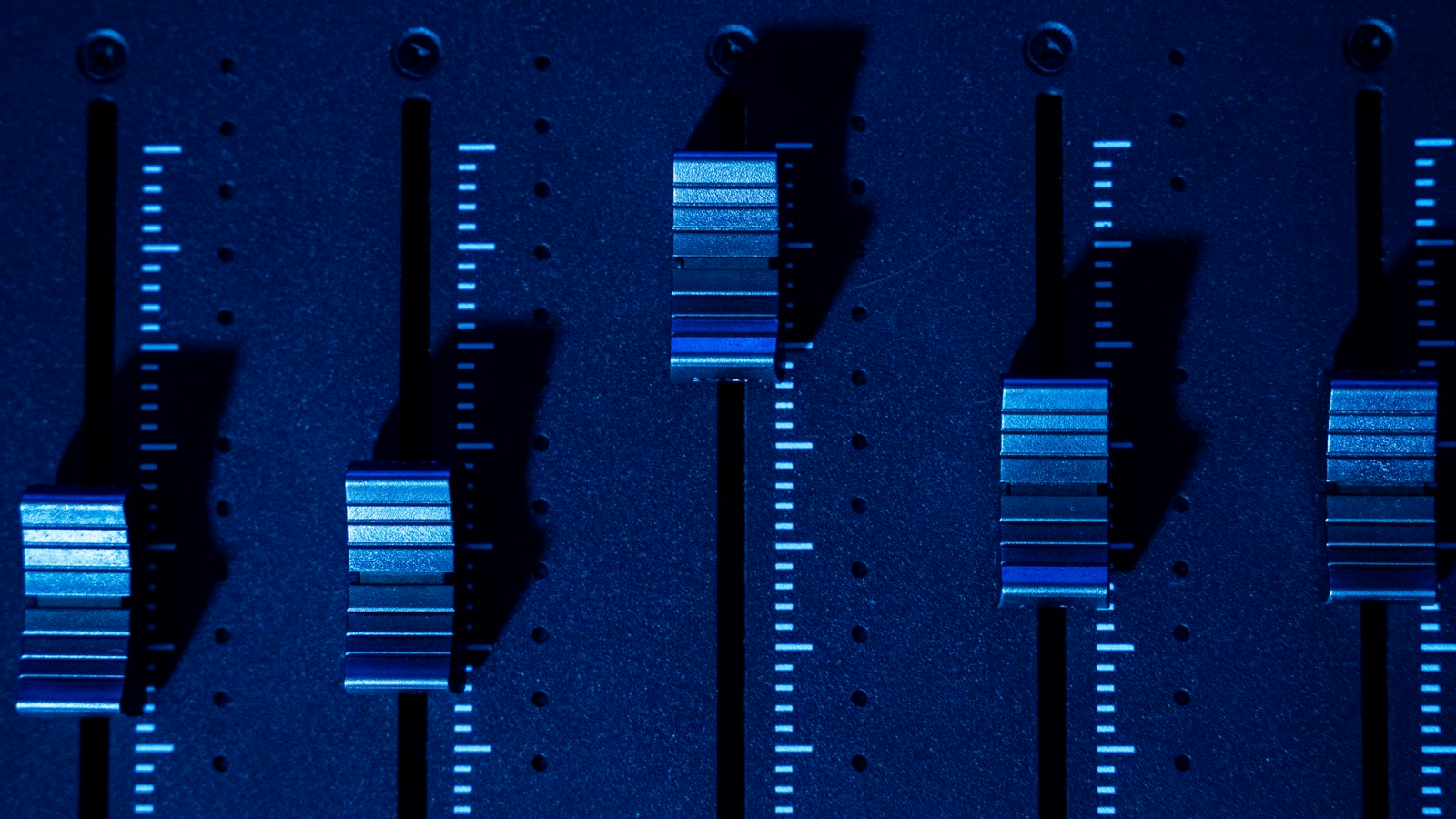 Mesa de som com faders em alturas diferentes, metáfora dos níveis de supervisão do human in the loop