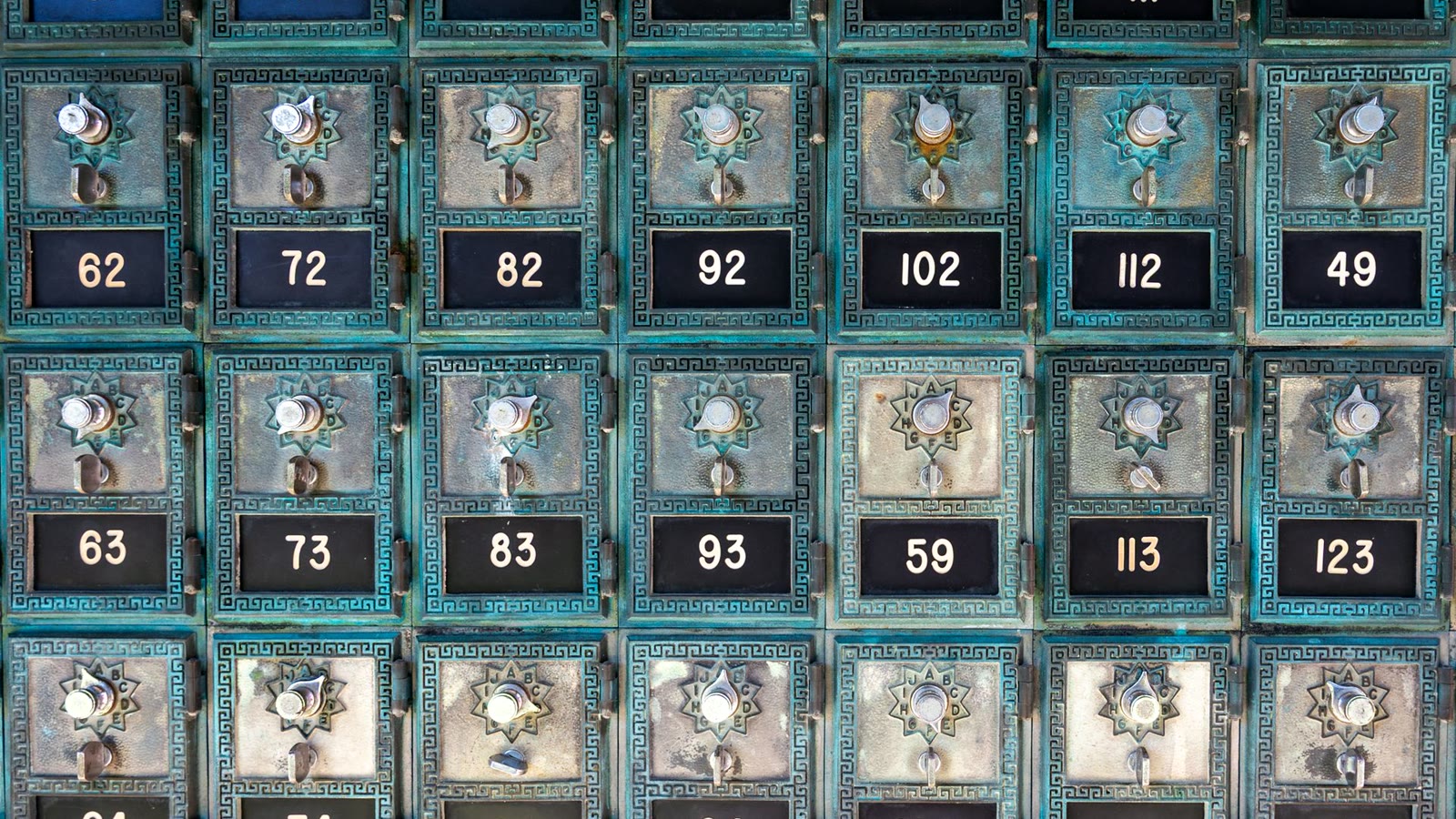 Caixas postais antigas numeradas em metal azul-petróleo, metáfora da triagem que a IA faz no email marketing