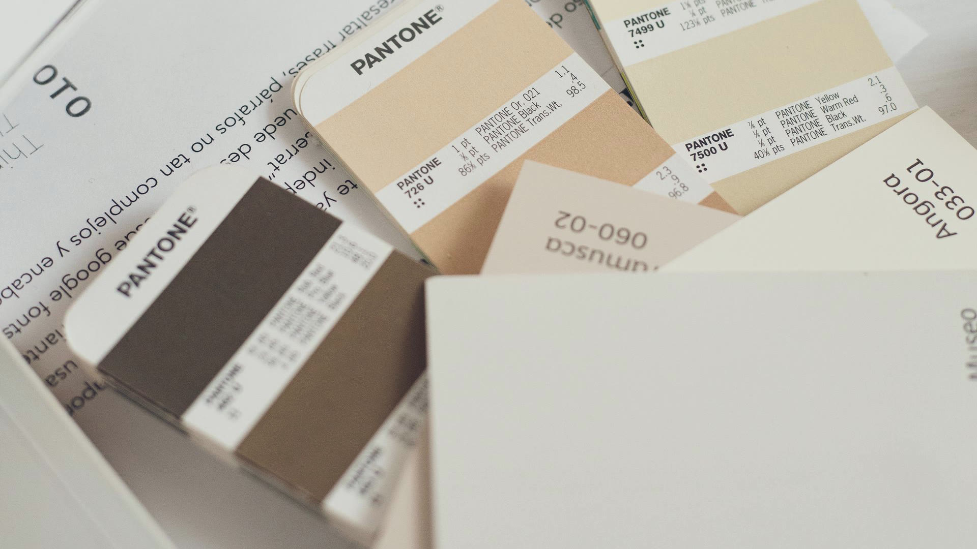 Amostras de cor Pantone sobre papel, a régua de marca que orienta o design com IA